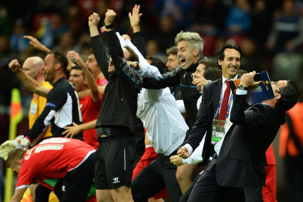 Sevilla's coach Unai Emery (second right) celebrates with team members at the final whistle. Photo: EPA