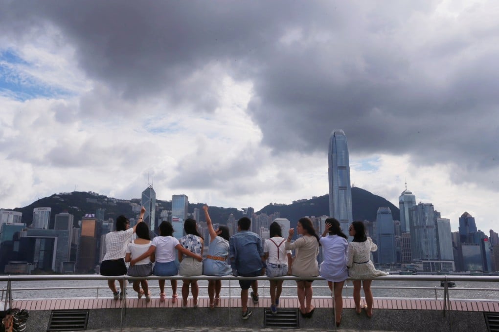 Tourists pose for a photo in Hong Kong's Tsim Sha Tsui district. Klook curates activities and experiences for visitors to multiple Asian cities. Photo: David Wong