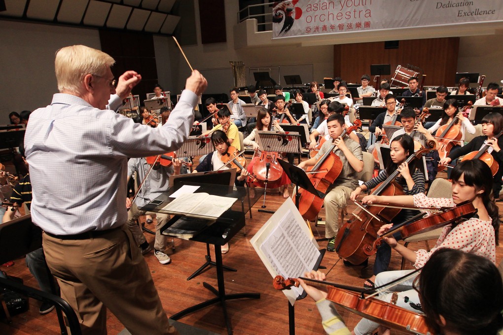 Richard Pontzious conducts Asian Youth Orchestra players in a rehearsal.