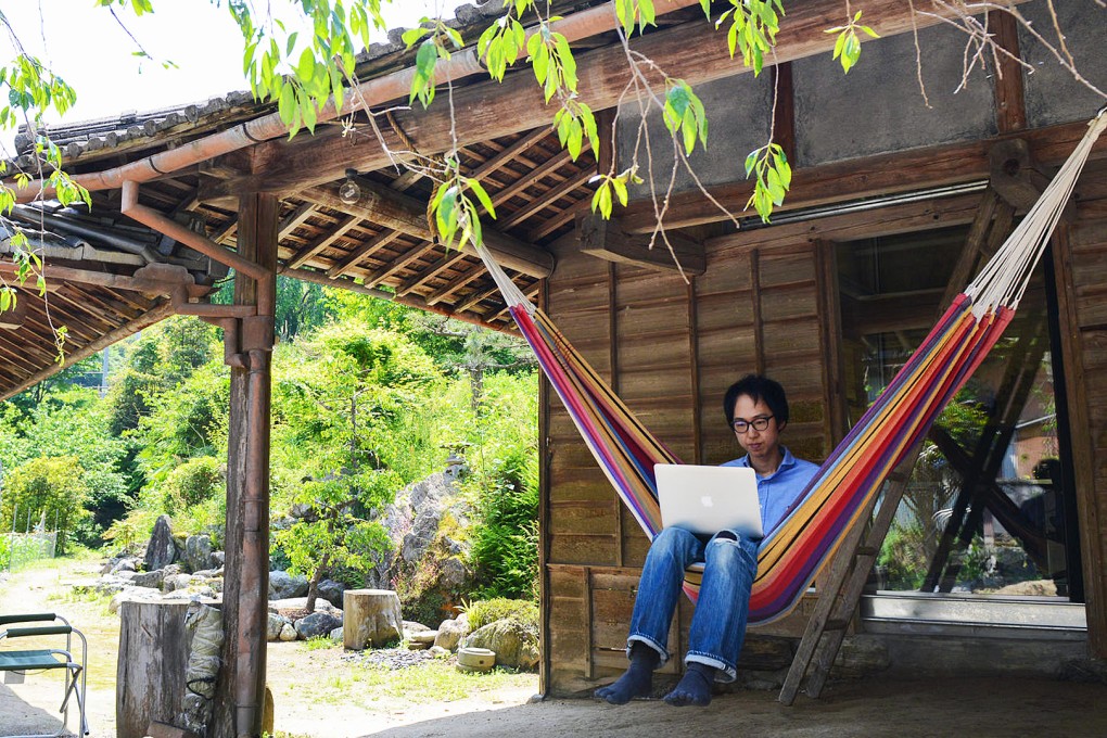 Developer Dan Yoichi works from a hammock at the kominka-style office of Sansan, one of the companies that has opened an office in Kamiyama, a rural town that faced a shrinking population. Photo: The Washington Post