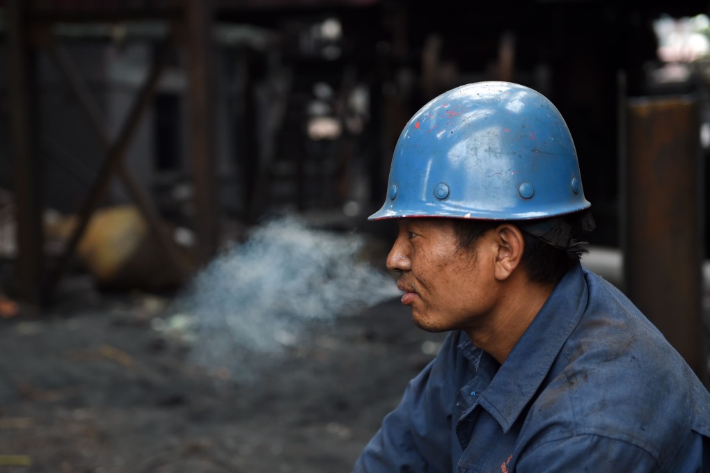 A worker lights up during a break at a demolition site in Beijing. Businesses that fail to rein in smoking on their premises could be fined up to 10,000 yuan. Photo: AFP