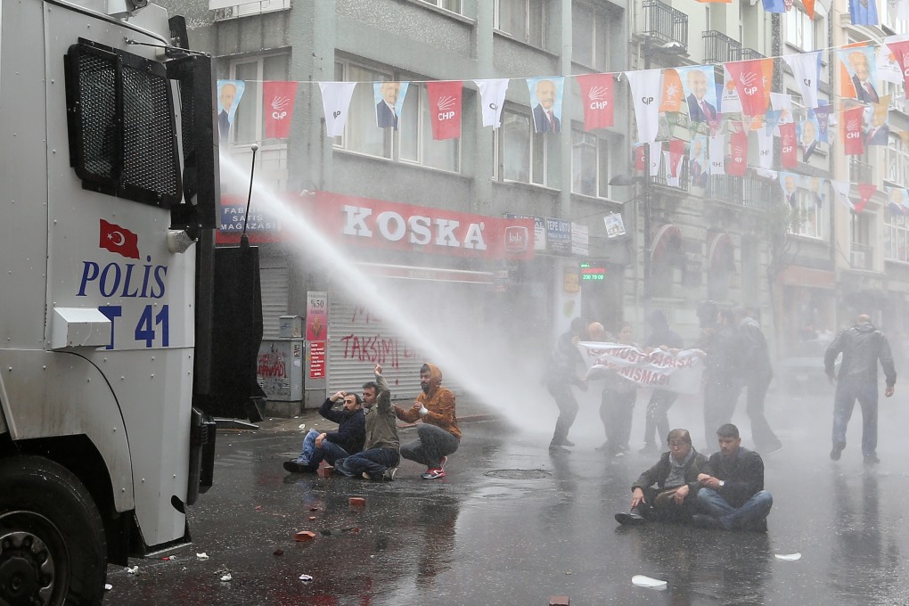 A police water cannon truck sprays protesters in Istanbul, Turkey. Photo: AP