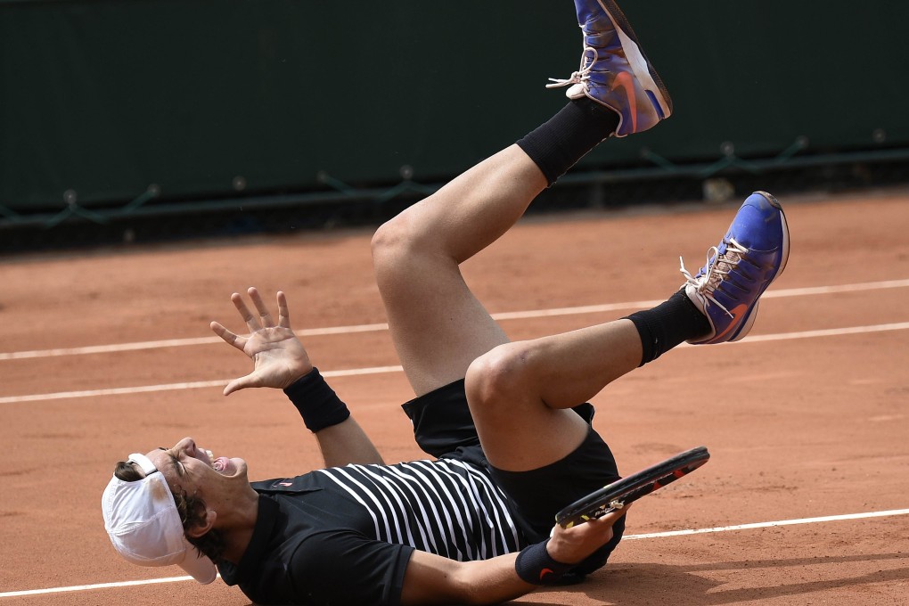 Thanasi Kokkinakis drops to the court as he celebrates defeating Australian compatriot Bernard Tomic. Photo: AFP