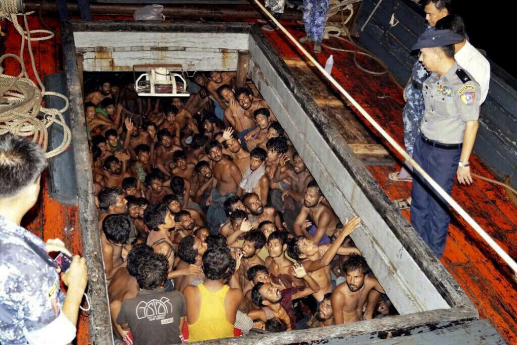 Myanmar police officers arrive on a fishing boat crammed with asylum seekers on the country's western coast, near Rakhine state. Photo: EPA