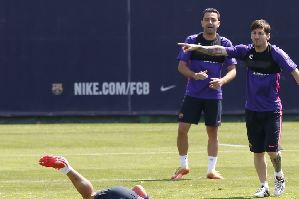 Barcelona's Lionel Messi and Xavi Hernandez (centre) gesture to teammate Luis Suarez as he tumbles on the field during a training session at the Barcelona training grounds in Sant Joan Despi near Barcelona. Photo: Reuters