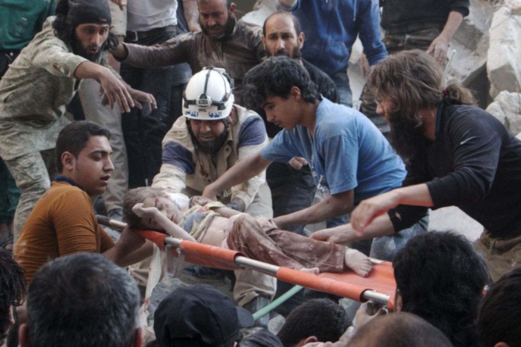 Syrian rescue workers and citizens carry a child on a stretcher from a building following a reported barrel bomb attack by Syrian government forces at the Al-Firdaws neighbourhood of the northern Syrian city of Aleppo. Photo: AFP
