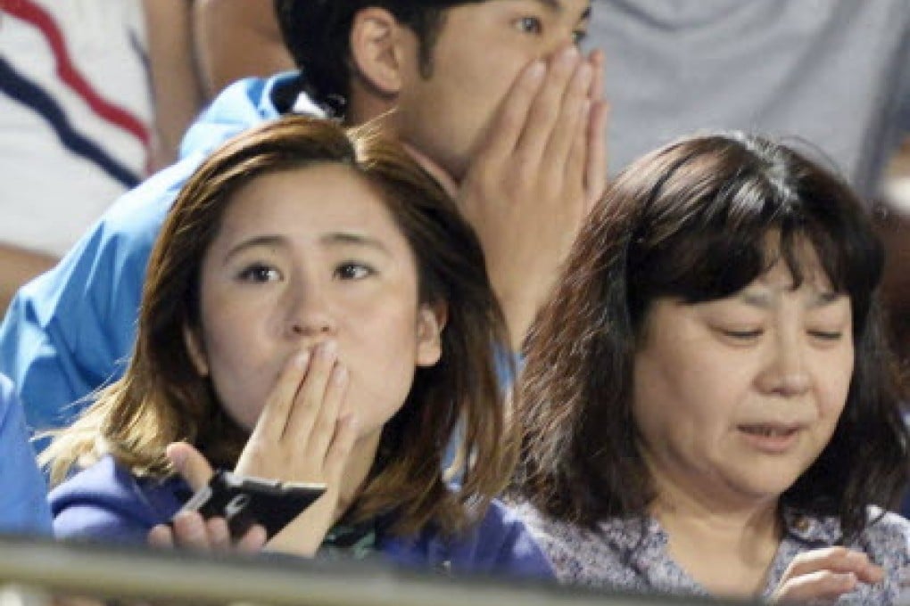 Worried soccer fans react to a strong earthquake in Hiratsuka, near Tokyo, on Saturday. Photo: Reuters