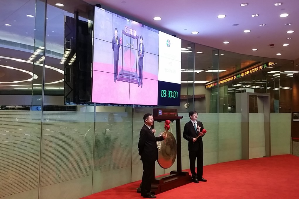 Officials of Huatai Securities bang the gong on Monday at the debut of their company in the Hong Kong stock exchange. Photo: Staff