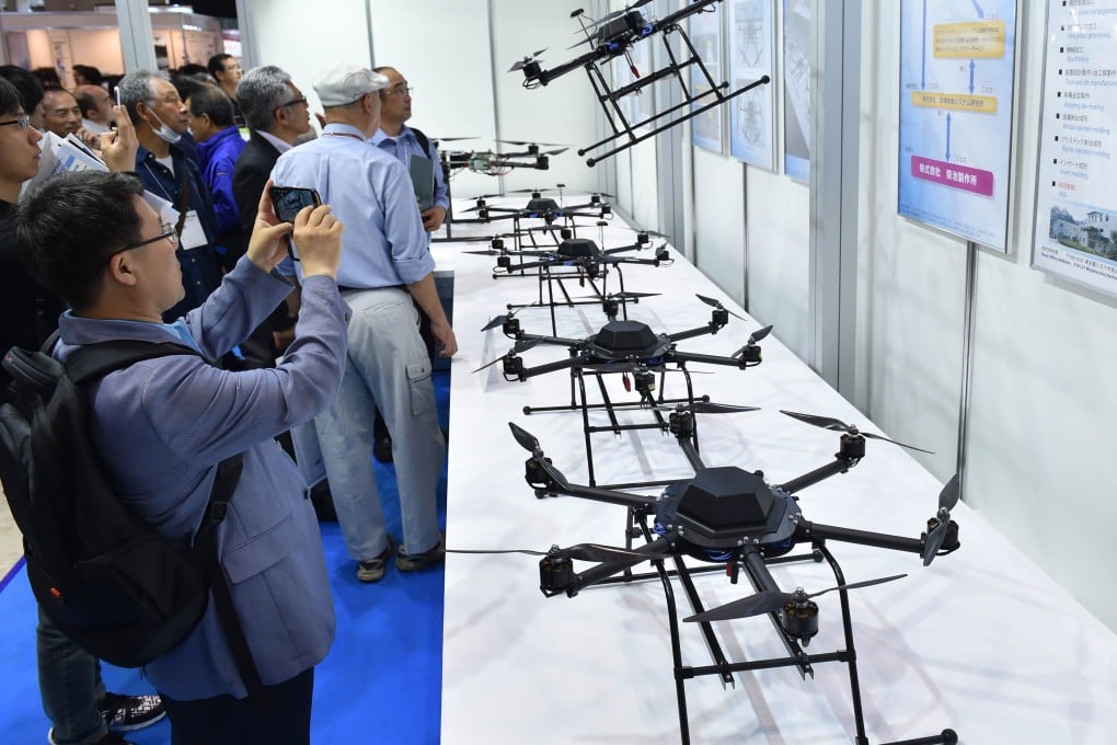 Visitors gather in front of an exhibition booth displaying recent models of drones during the International Drone Expo in Tokyo on May 20, 2015. Photo: AFP