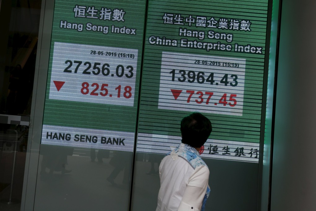 A passersby looks at a screen showing the Hang Seng index in Hong Kong as shares in the city and on mainland China have rallied strongly the past few weeks. Photo: Reuters