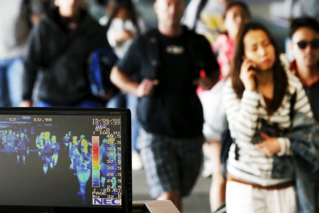 Passengers wearing masks to prevent contracting Middle East Respiratory Syndrome (MERS) walk past a thermal imaging camera at Incheon International Airport in Incheon, South Korea. Photo: Reuters