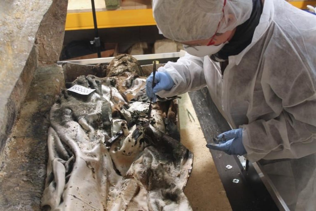 A photo released by the French National Institute for Preventive Archaeological Research shows an archeologist opening of a coffin containing the body of a noble woman in Rennes. Photo: AFP