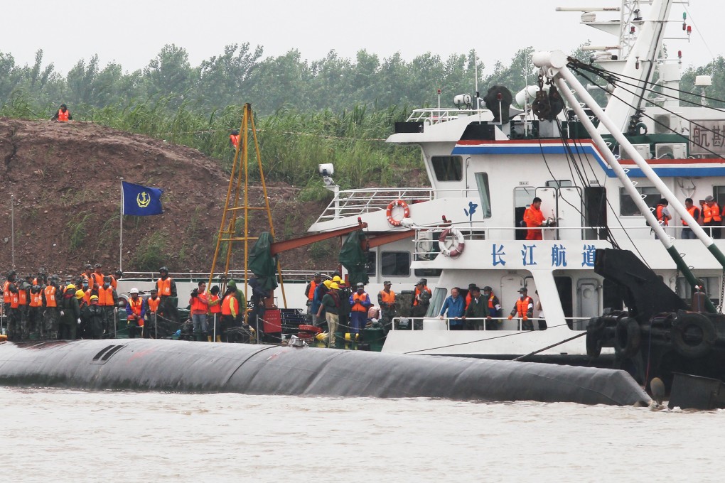 Rescuers stand in the bottom of the sunk ship. Photo: Simon Song