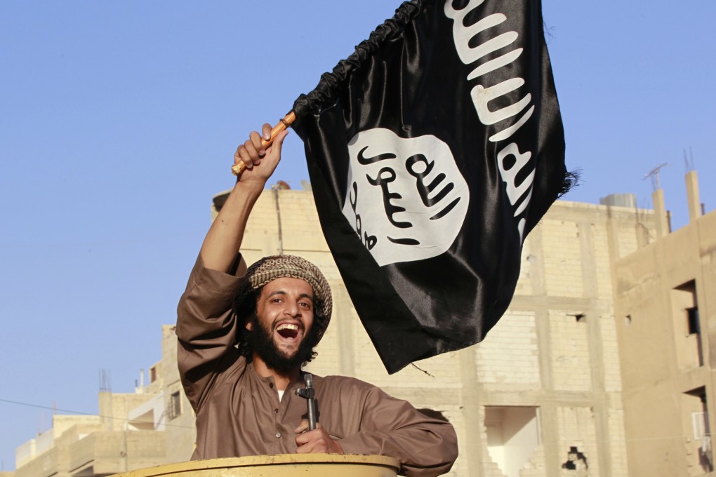 An Islamic State fighter waves the group's flag as he takes part in a military parade along the streets of Syria's northern Raqqa province. Photo: Reuters