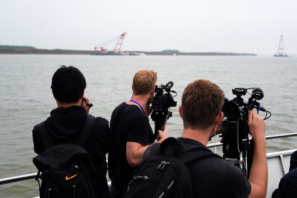 Foreign cameramen work at the site of the overturned passenger ship in the Jianli section of the Yangtze River in central China's Hubei Province. Photo: Xinhua