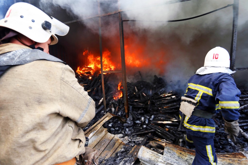 Firemen extinguish a fire at a market in Donetsk after shelling between Ukrainian forces and pro-Russian separatists on June 3. Photo: AFP