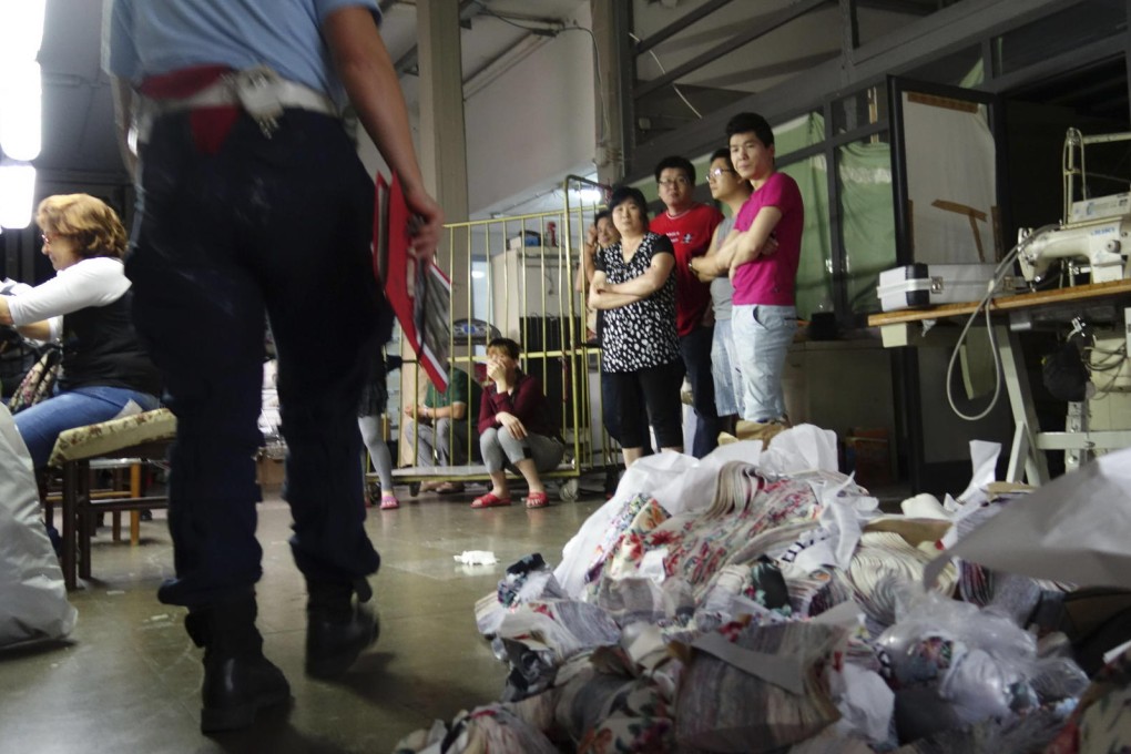 Chinese labourers questioned at a factory in Prato, Italy. Photo: AP