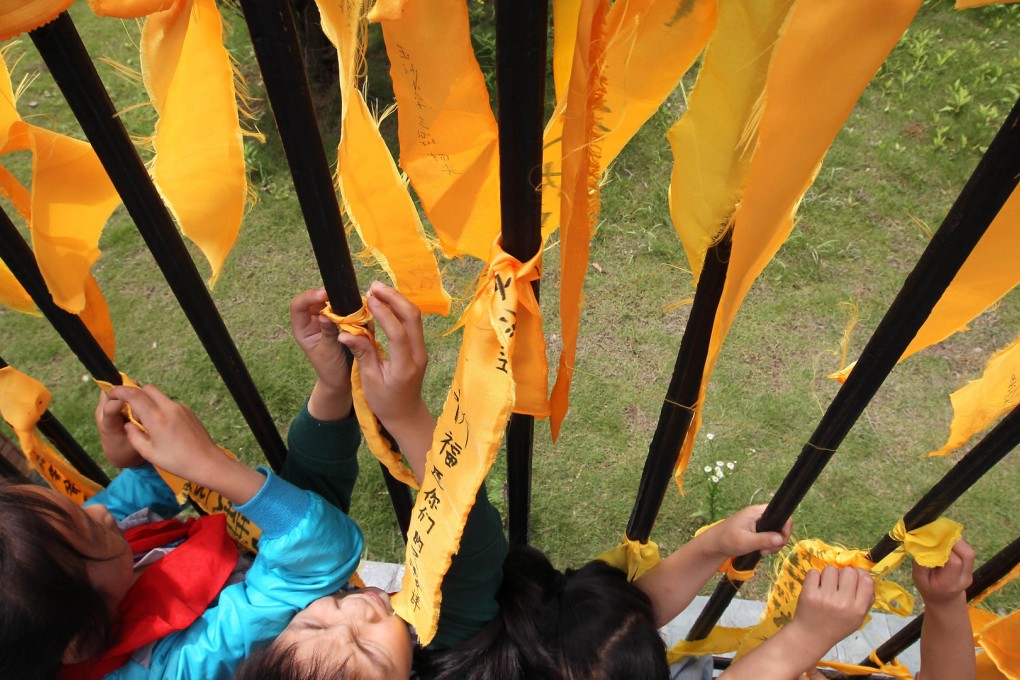 Pupils tie ribbons with messages of support for the families of victims of the Eastern Star disaster on the Yangtze River. Photo: Simon Song