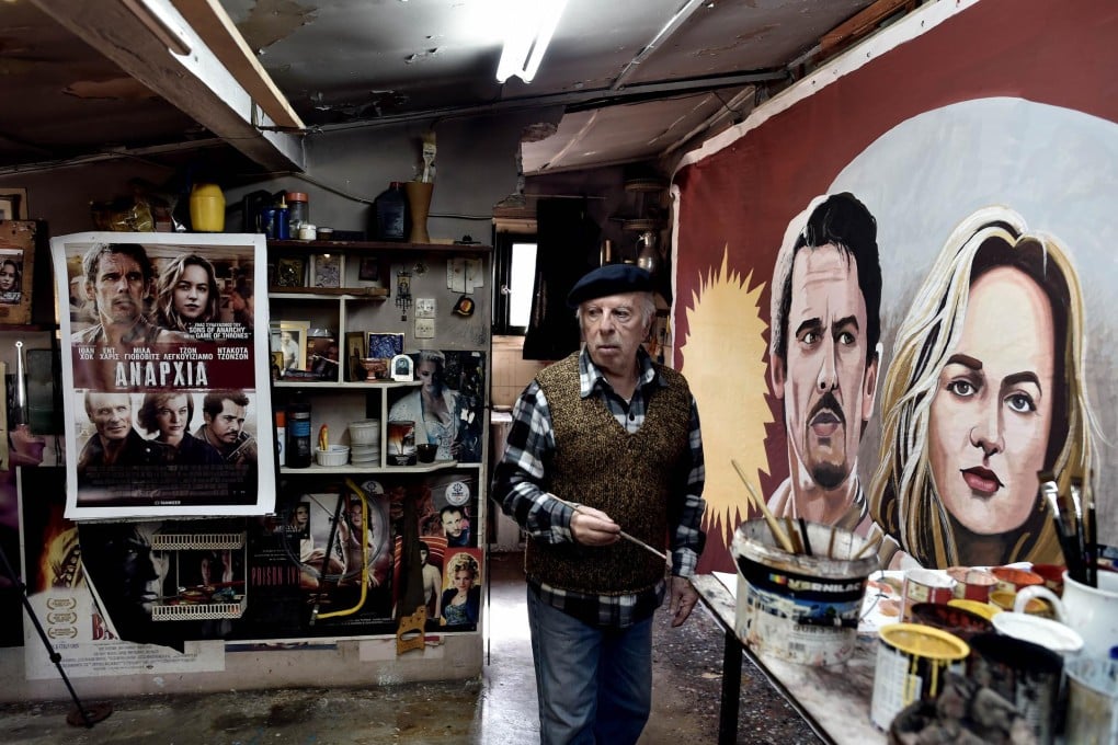 Greek billboard artist Vassilis Dimitriou works alone on a poster at his studio in Athens. In his heyday he had two assistants. Photo: AFP