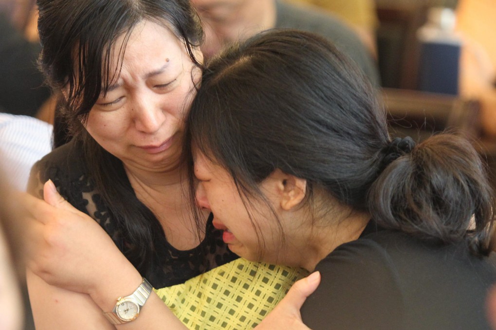 Two women cry at a meeting with officials in Jianli county. Photo: Simon Song.