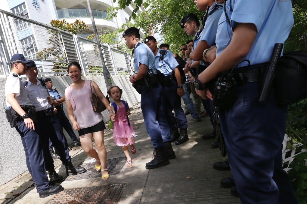 Police stand guard outside a school-place allocation centre in Sheung Shui yesterday. Photo: K. Y. Cheng