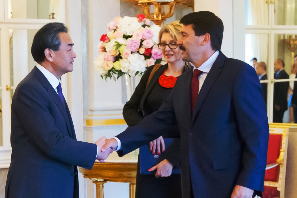 Chinese Foreign Minister Wang Yi shakes hands with Hungarian President Janos Ader in Budapest. Photo: Xinhua