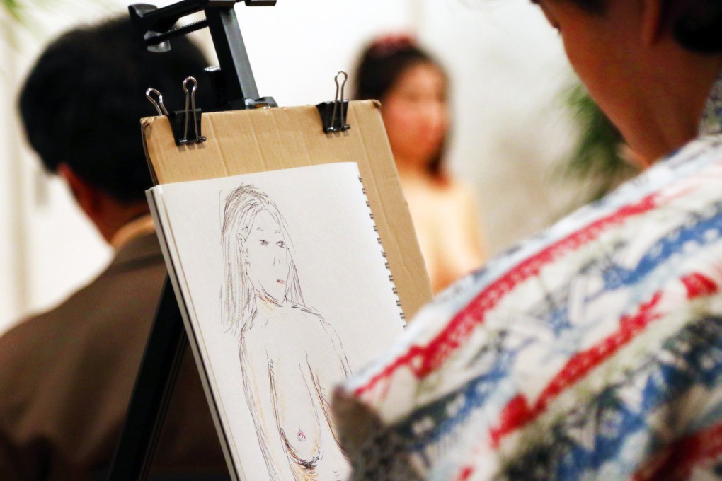 Middle aged men sketch a nude model at the Virgin Academia studio in Tokyo as part of a scheme to help participants understand the female body. Photo: AFP