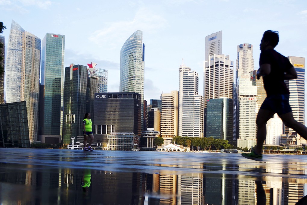 Joggers pass the skyline of the central business district in Singapore. Photo: Reuters