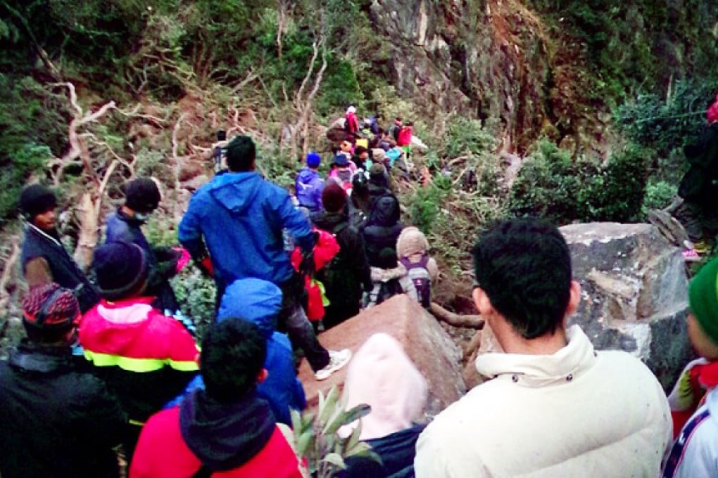 Climbers trek down the Timpohan Trail with the help of local mountain guides on Mount Kinabalu after it was struck by a strong earthquake. Photo: AP