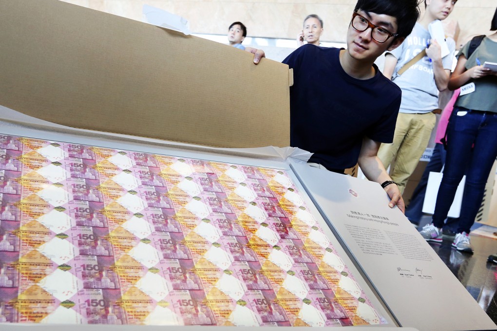 Fred Chan, winner of a lottery to purchase HSBC's 150th anniversary banknotes, poses for picture for the press at  the Hong kong Convention and Exhibition Center in Wan Chai.  Photo: Sam Tsang