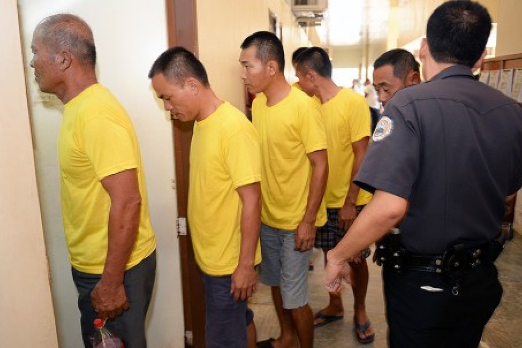 A Philippine prison guard escorts nine arrested Chinese fishermen as they arrive at a courtroom for a pre-trial in Puerto Princesa City, Palawan, in this file photo. Photo: AFP