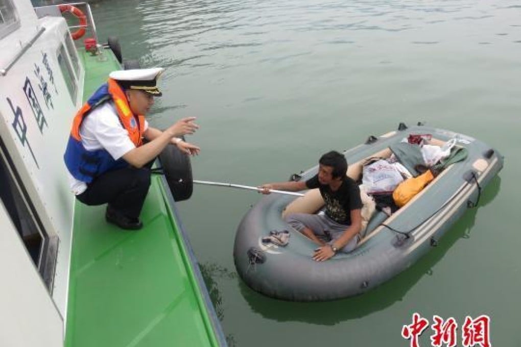 A patrol officer questions Tang who was found paddling in the Three Gorges Dam. Photo: China News