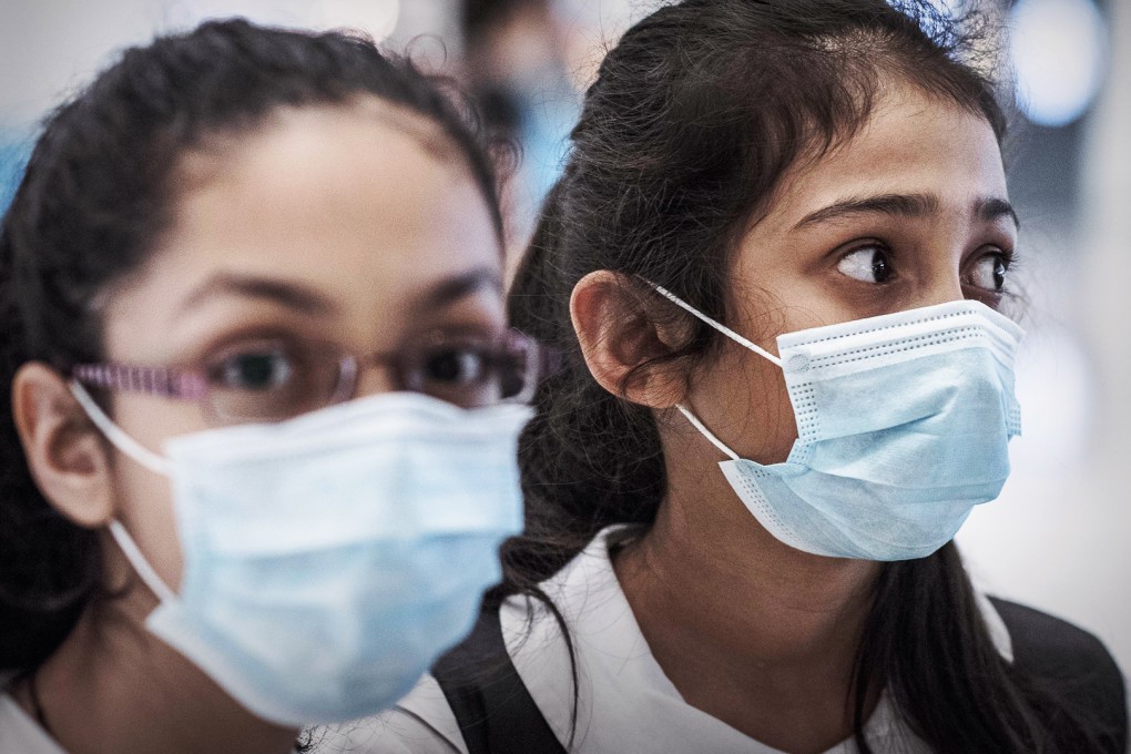 Schoolchildren wear masks at Tsing Yi MTR station on Wednesday after a woman suspected to have Mers reported to a clinic there. The woman later tested negative for the virus. Photo: AFP