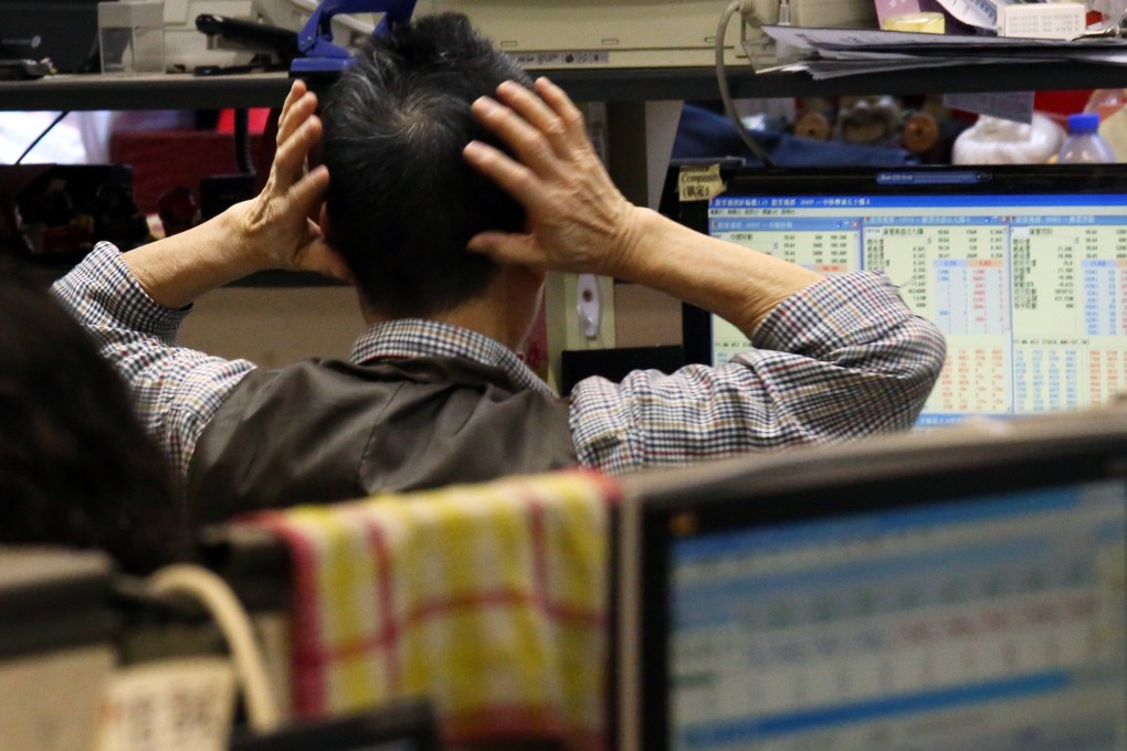 A trader in Hong Kong grabs his head in consternation. The exchange operator, Hong Kong Exchanges and Clearing, is putting in a system to fight the sharp volatility caused by high-frequency traders. Photo: Nora Tam