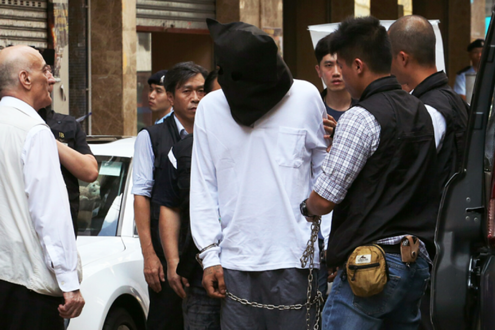 The hooded suspect was taken to the scene of the alleged murder today. Photo: Felix Wong