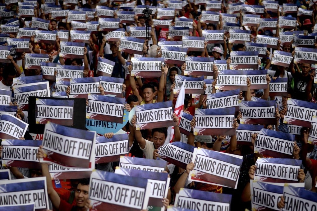 Protesters wave signs in front of the Chinese consulate on Philippine Independence Day. Photo: AFP