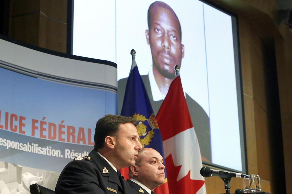 Royal Canadian Mounted Police assistant commissioner James Malizia (left) and Inspector Paul Mellon speak at a press conference at RCMP headquarters in Ottawa, Ontario, about the arrest of a Somali man Ali Omar Ader, shown on the screen, for his involvement in the kidnapping of Canadian journalist Amanda Lindhout and Australian photojournalist Nigel Brennan. Photo: AP