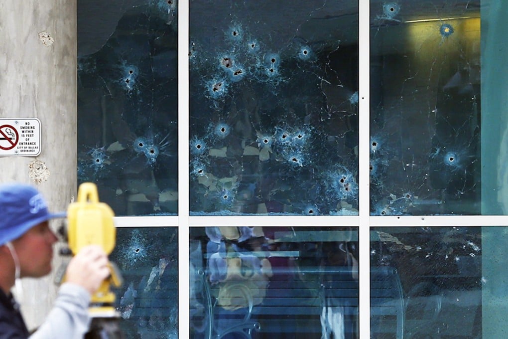 With bullet holes in the side of the Dallas Police headquarters, Bill Smith of the FBI works the scene after an early morning shooting on June 13, 2015, in Dallas. Photo: AP