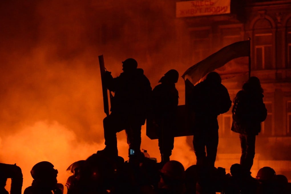 Ukrainian anti-government protesters stand on a makeshift barricade during clashes with riot police in central Kiev late in January 2014. Photo: AFP