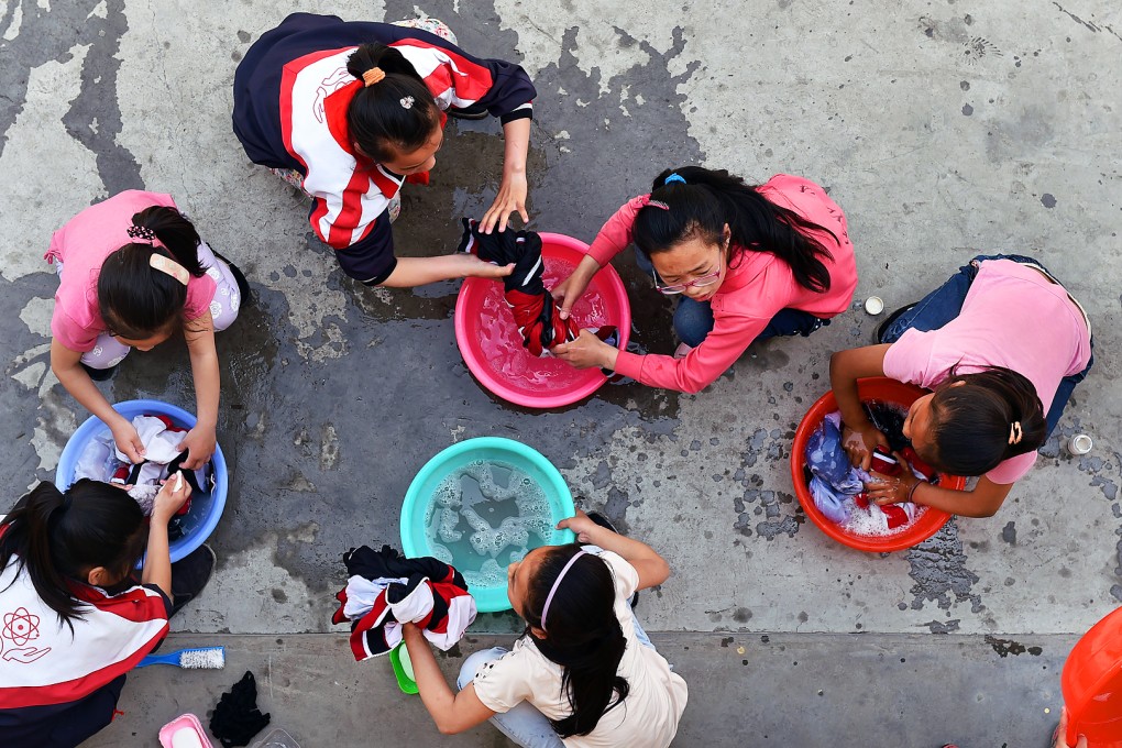 Children do their laundry at a boarding school in rural China. Many of the pupils at the school are "left behind" children whose parents have headed for the big cities in search of work. Photo: Xinhua