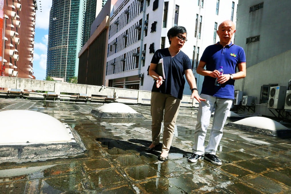 Rebecca Yip and Peter Ng inspect the parlour roof. Photo: David Wong