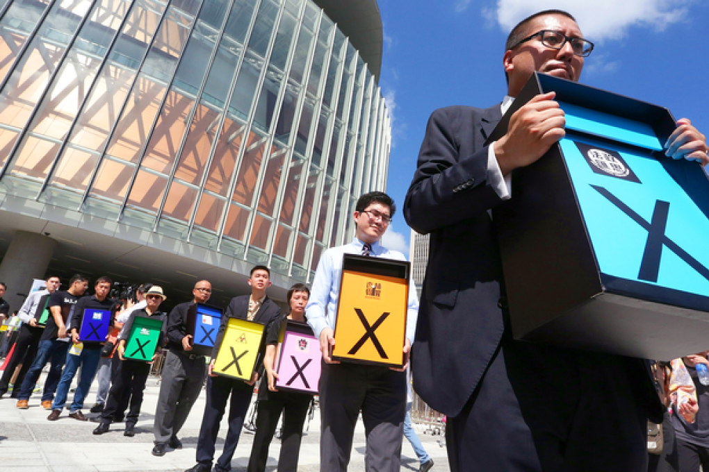 A group of activists, including members of the Progressive Lawyers Group, hold placards outside Legco. Photo: Felix Wong