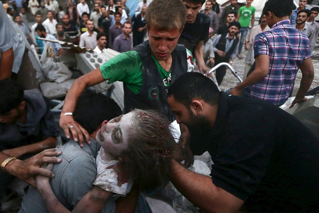 Men hold an injured girl saved from under rubble after forces loyal to Syria's President Bashar al-Assad shelled the Douma neighborhood of Damascus. Photo: Reuters