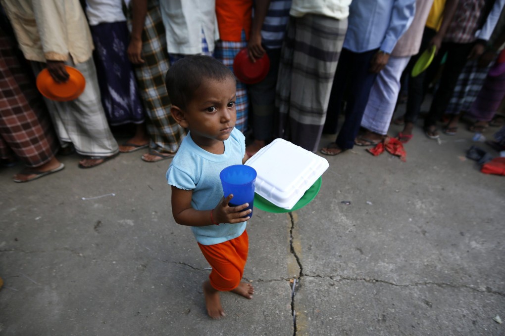A Rohingya child receives food during the break of fasting on the first day of the Muslim fasting month, in a refugee camp in Aceh, Indonesia. Photo: EPA