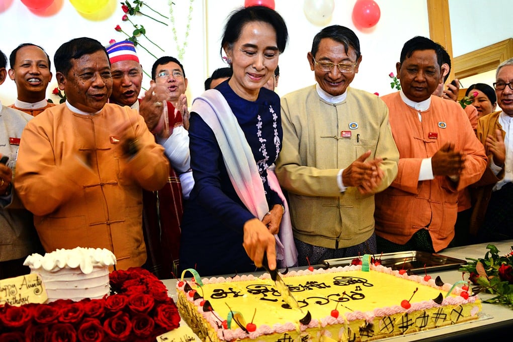Myanmar's opposition leader Aung San Suu Kyi cuts her birthday cake as members of her National League for Democracy party sing during a celebration of her 70th birthday at a parliament building on Friday  in Naypyitaw, Myanmar. Photo: AP