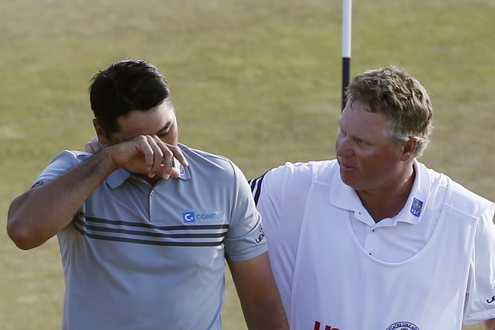 Jason Day walks off the 18th green with his caddie, Colin Swatton, after the third round at Chambers Bay in University Place, Washington. Photo: AP
