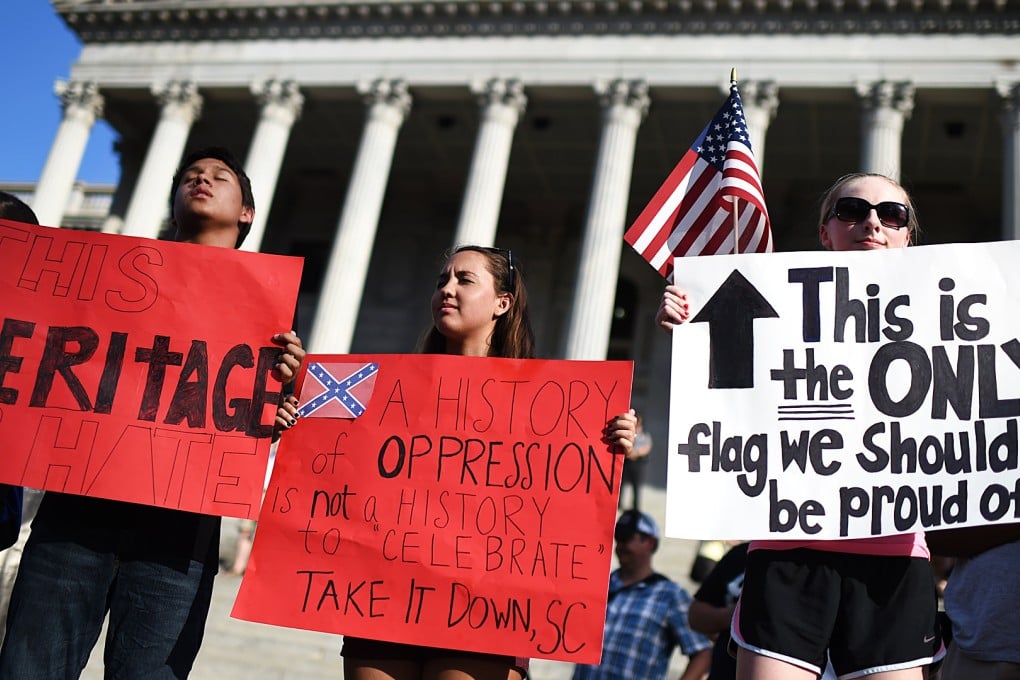 Protesters close their eyes in silent prayer as they stand on the South Carolina Statehouse steps during a rally to take down the Confederate flag in Columbia, S.C. Photo: AP