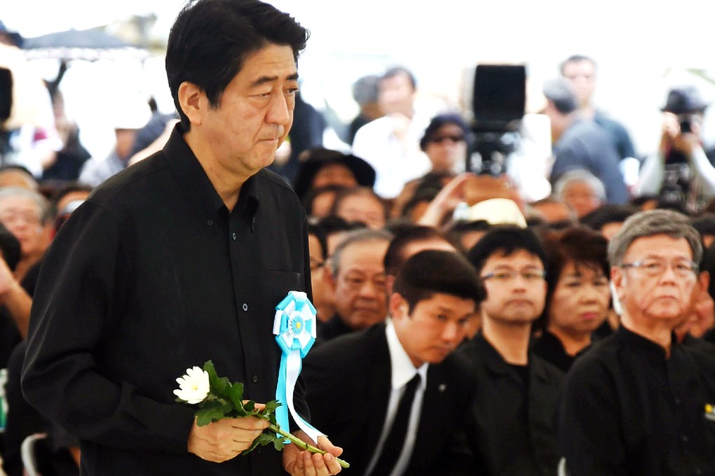 Japan's Prime Minister Shinzo Abe offers a chrysanthemum on an altar during a memorial service for those who died in the battle of Okinawa during the second world war at the Peace Memorial Park in Itoman. Photo: AFP