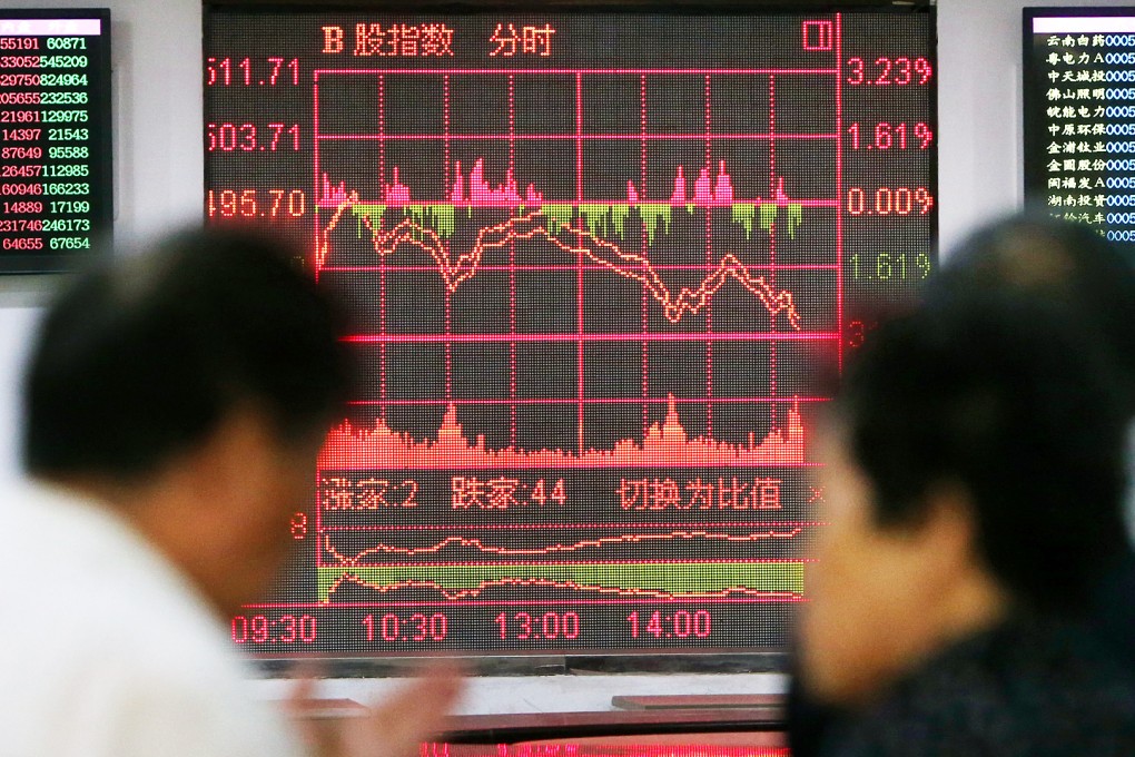 Investors look through stock information at a trading hall in a securities firm in Shanghai on June 19, 2015. Photo: Xinhua