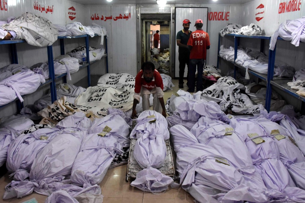 Rescue workers move the bodies of the victims of heatwave at a mortuary in Karachi. Photo: EPA